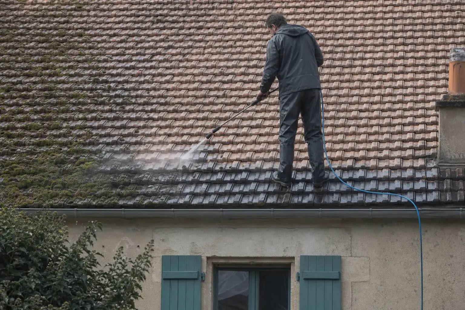 Lance basse pression rinçant un versant moussu, ruissellement sombre sous la ligne de travail